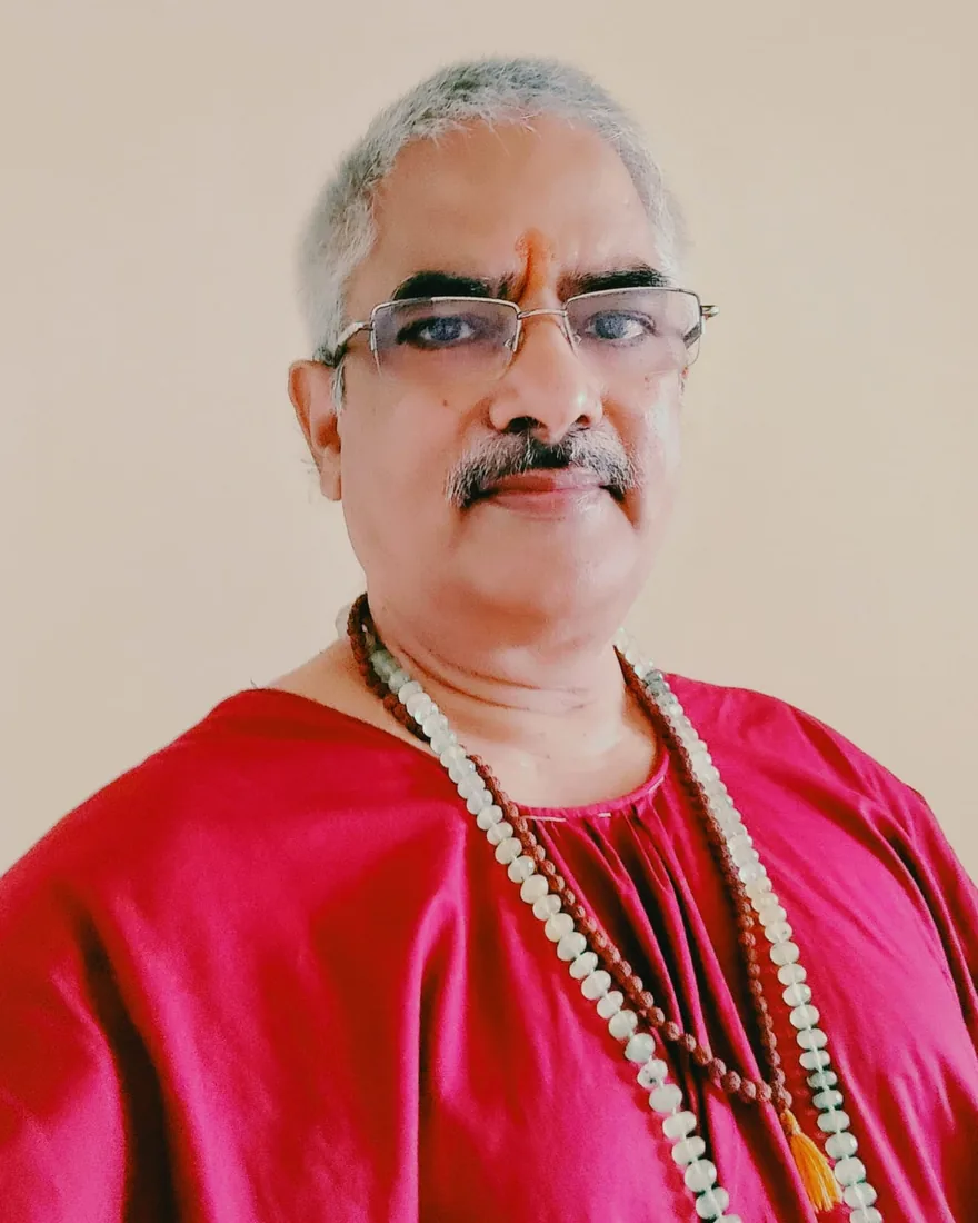 Sharwan Mishra, astrology and vastu consultant, wearing a crimson kurta with rudraksha and crystal malas
